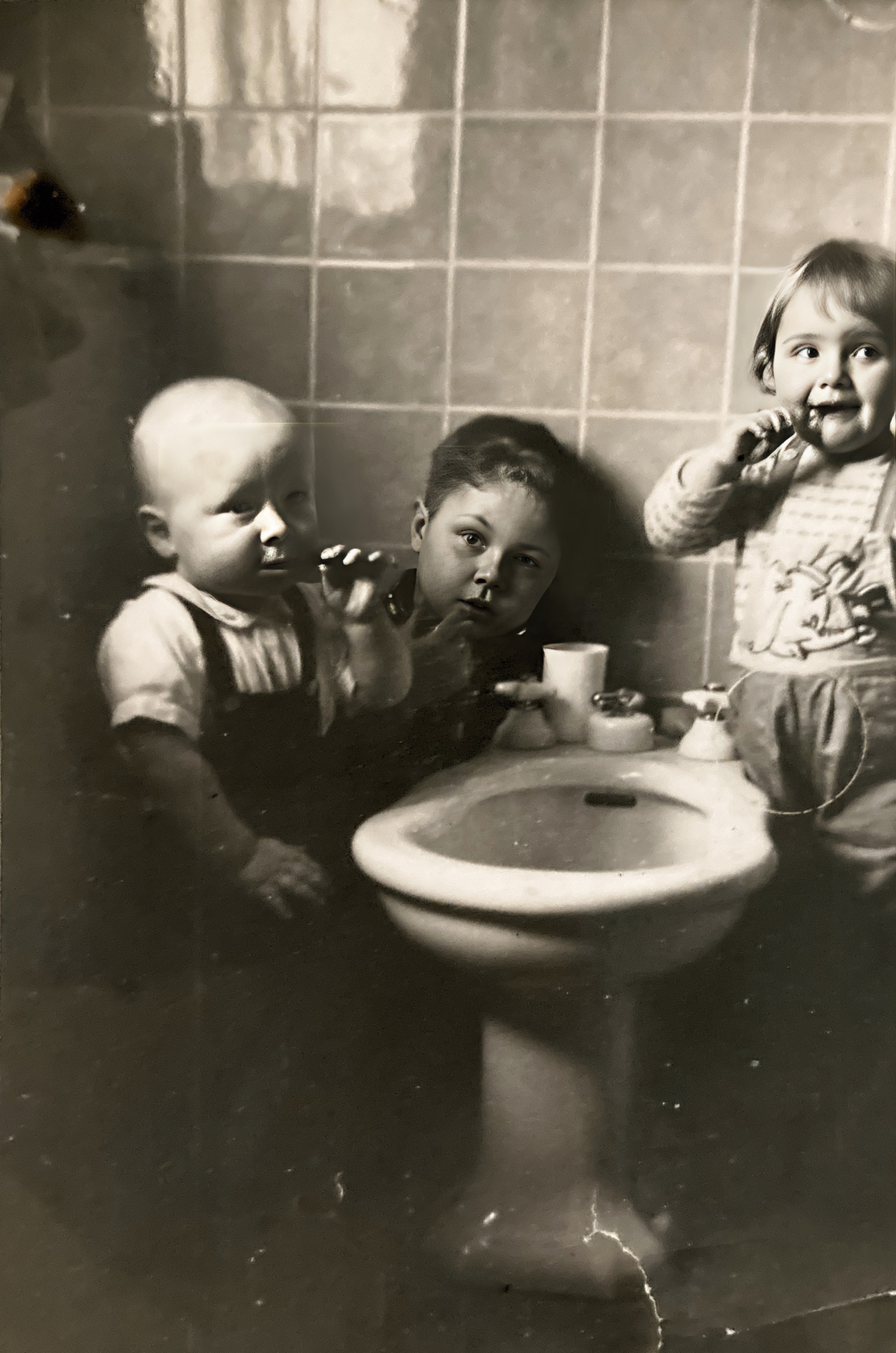 Vernon, Billy, and Chantal brushing teeth from bidet. 1953 France